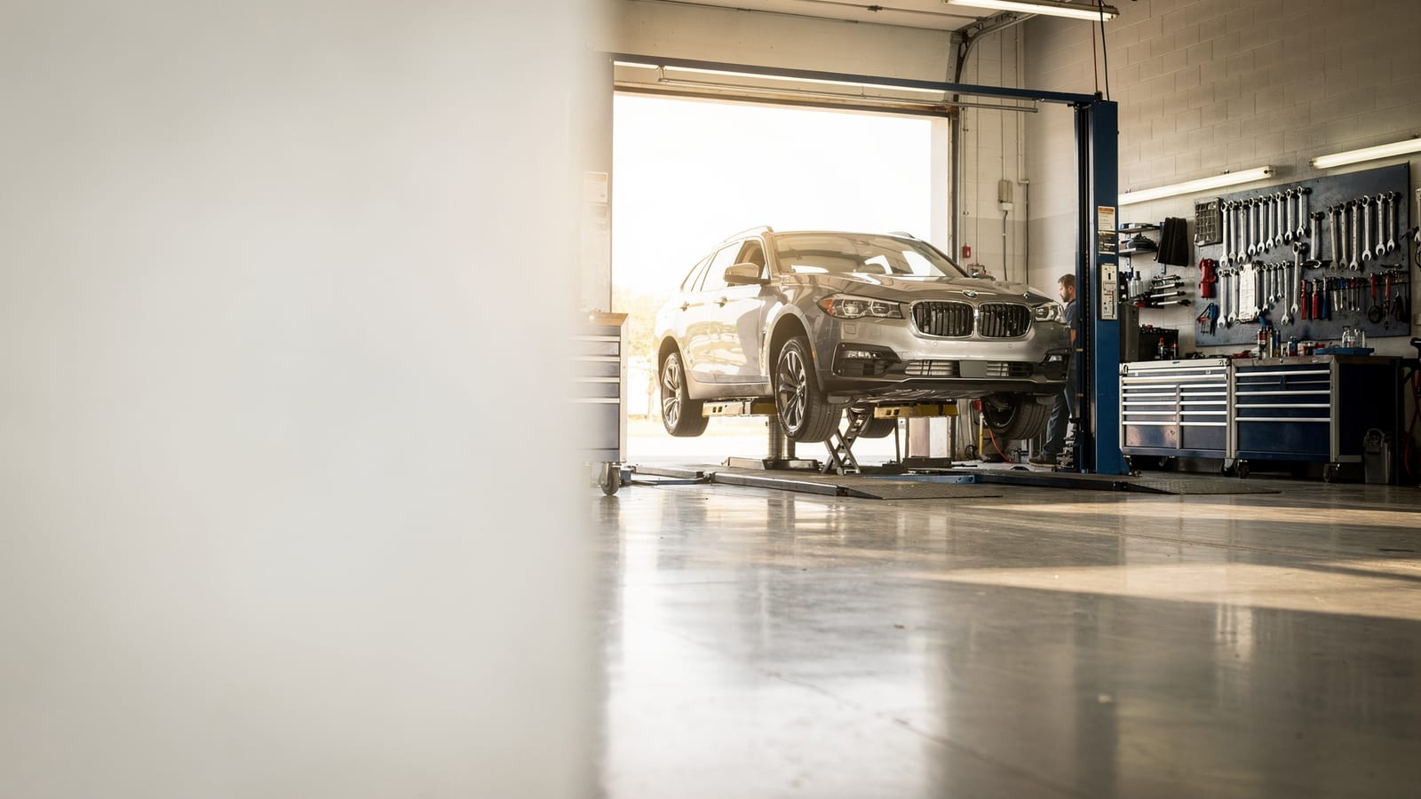 A car up on the lift in the bright service bay at Edwards Auto Repair in Denver